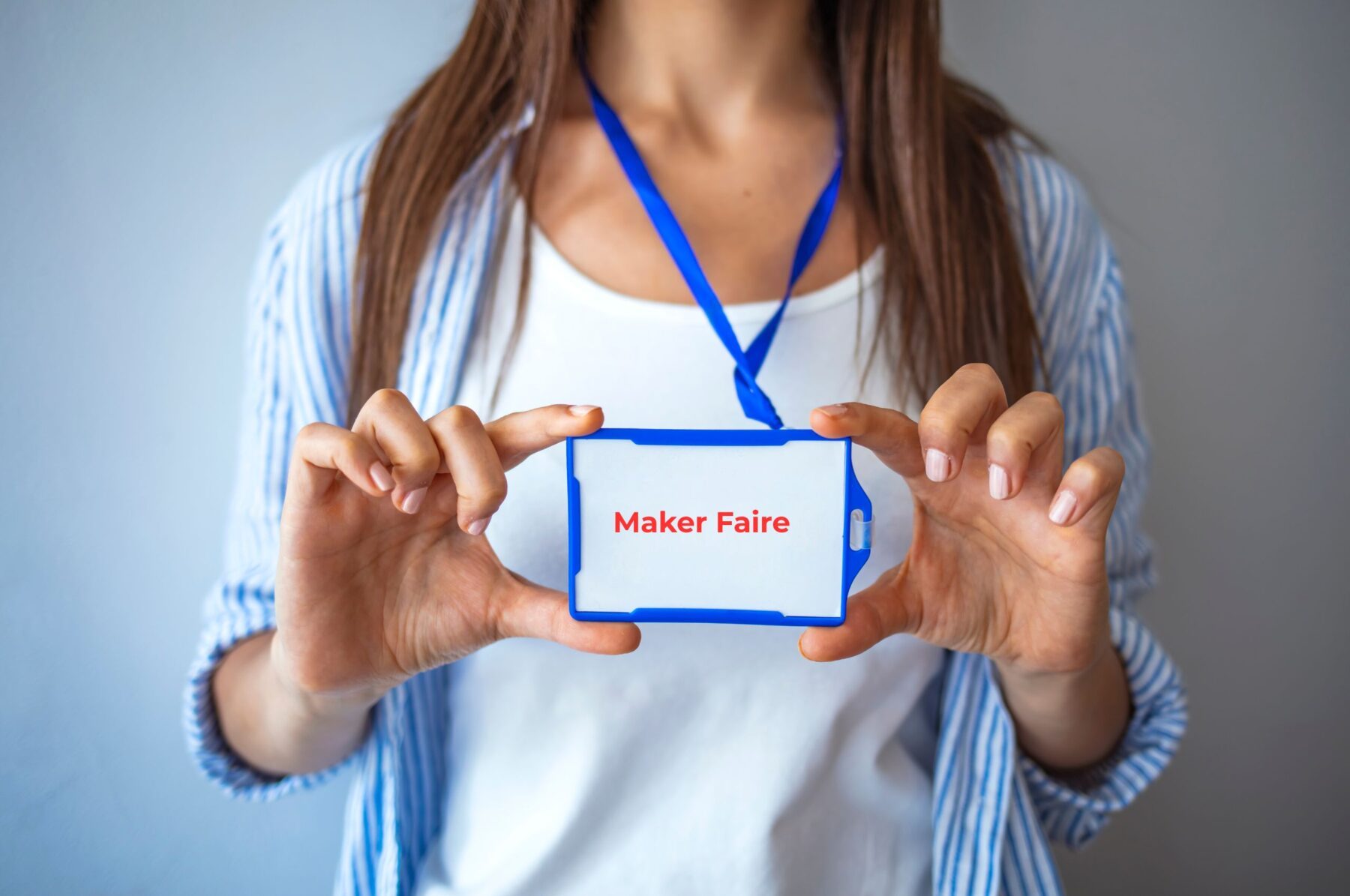 junge Frau mit Messebadge und Aufschrift Maker Faire